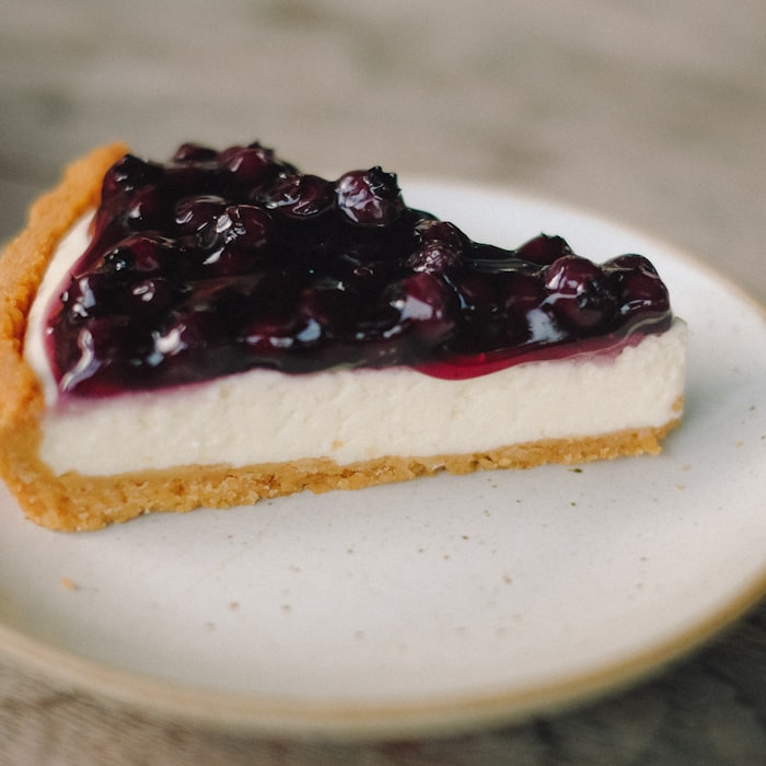 A slice of creamy cheesecake on a crunchy biscuit base